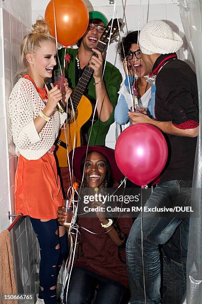 friends laughing in bathtub at party - lollipop man stockfoto's en -beelden