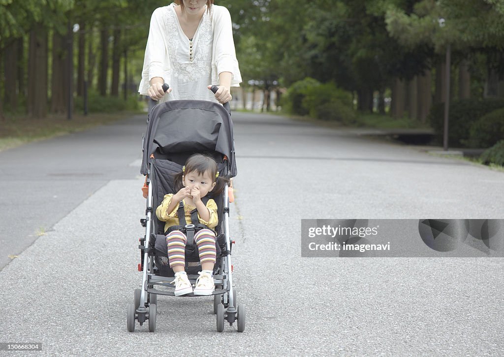 Mother with daughter in stroller taking a walk