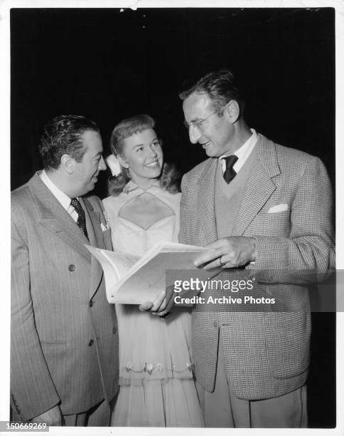 Musical director Ray Heindorf, Doris Day, and music synchronizer Sid Sidney discuss the score of one of her songs in between scenes from the film 'On...