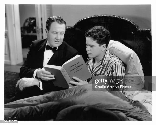 Ian Hunter sharing book with Gene Reynolds in a scene from the film 'Gallant Sons', 1940.