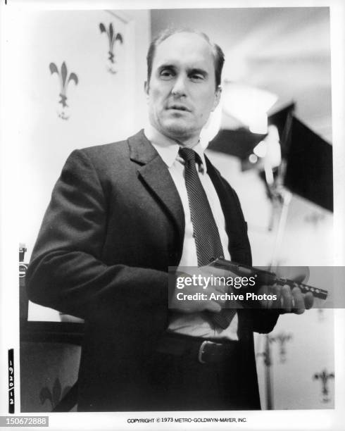 Robert Duvall holding gun in a scene from the film 'The Outfit', 1973.