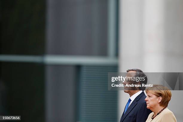 German Chancellor Angela Merkel and Greek Prime Minister Antonis Samaras review a guard of honour upon Samaras arrival at the Chancellery on August...