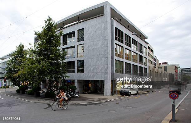 Cyclists rides past the building that houses the headquarters of Xstrata Plc in Zug, Switzerland, on Friday, Aug. 24, 2012. Glencore's planned...
