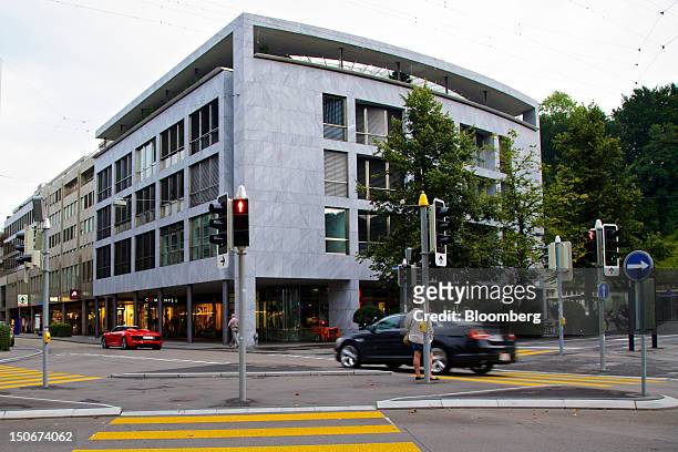 Pedestrian waits at an intersection in front of building that houses the headquarters of Xstrata Plc in Zug, Switzerland, on Friday, Aug. 24, 2012....