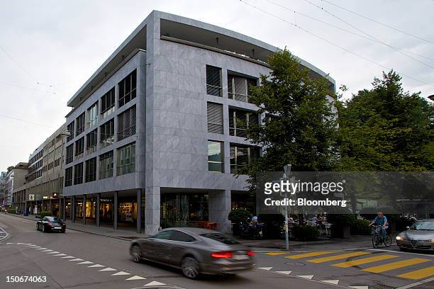 Luxury automobiles are driven past the building that houses the headquarters of Xstrata Plc in Zug, Switzerland, on Friday, Aug. 24, 2012. Glencore's...