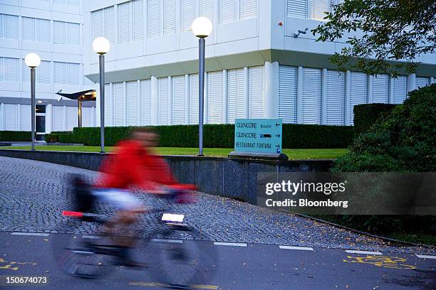 Cyclist passes the entrance to Glencore International Plc's headquarters in Baar, Switzerland, on Friday, Aug. 24, 2012. Glencore's planned takeover...