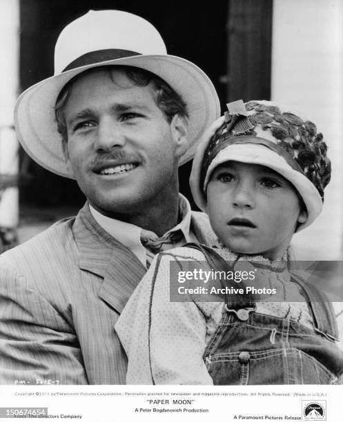 Ryan O'Neal holding Tatum O'Neal in a scene from the film 'Paper Moon', 1973.