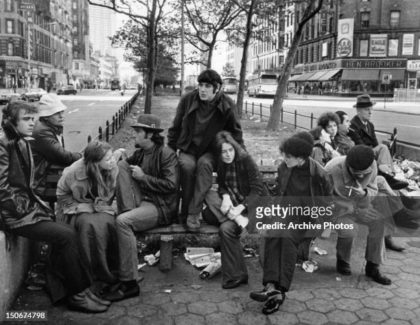 The gang, including Al Pacino and Kitty Winn, sit around on a bench in a scene from the film 'The Panic In Needle Park', 1971.