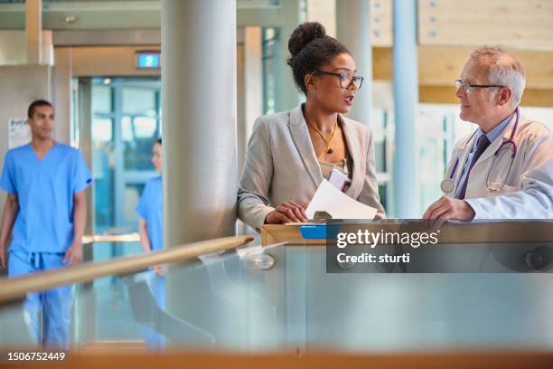 doctor chatting with medical sales rep - medical sales representative stock pictures, royalty-free photos & images