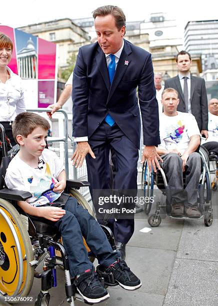 British Prime Minister David Cameron meets with flame ambassadors after the Olympic cauldron was lit for the Paralympic Games in Trafalgar Square on...