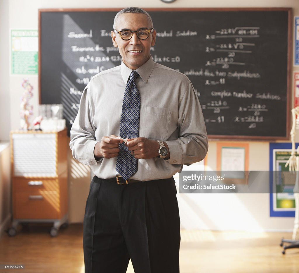 Male school teacher in front of blackboard