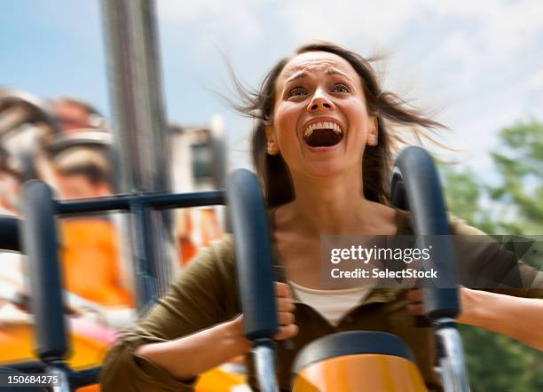 joven mujer pateando una montaña rusa - montaña rusa fotografías e imágenes de stock