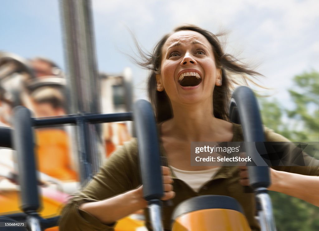 Young woman screaming on a rollercoaster