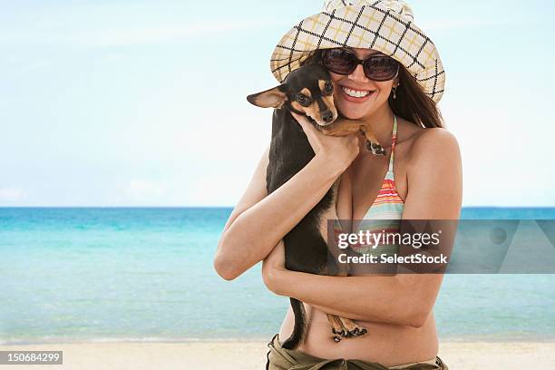 young woman on the beach holding small dog - dog sunglasses stock pictures, royalty-free photos & images