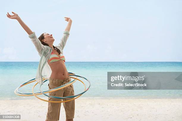 junge frau am strand spielen mit hula-ringe - gymnastikreifen stock-fotos und bilder