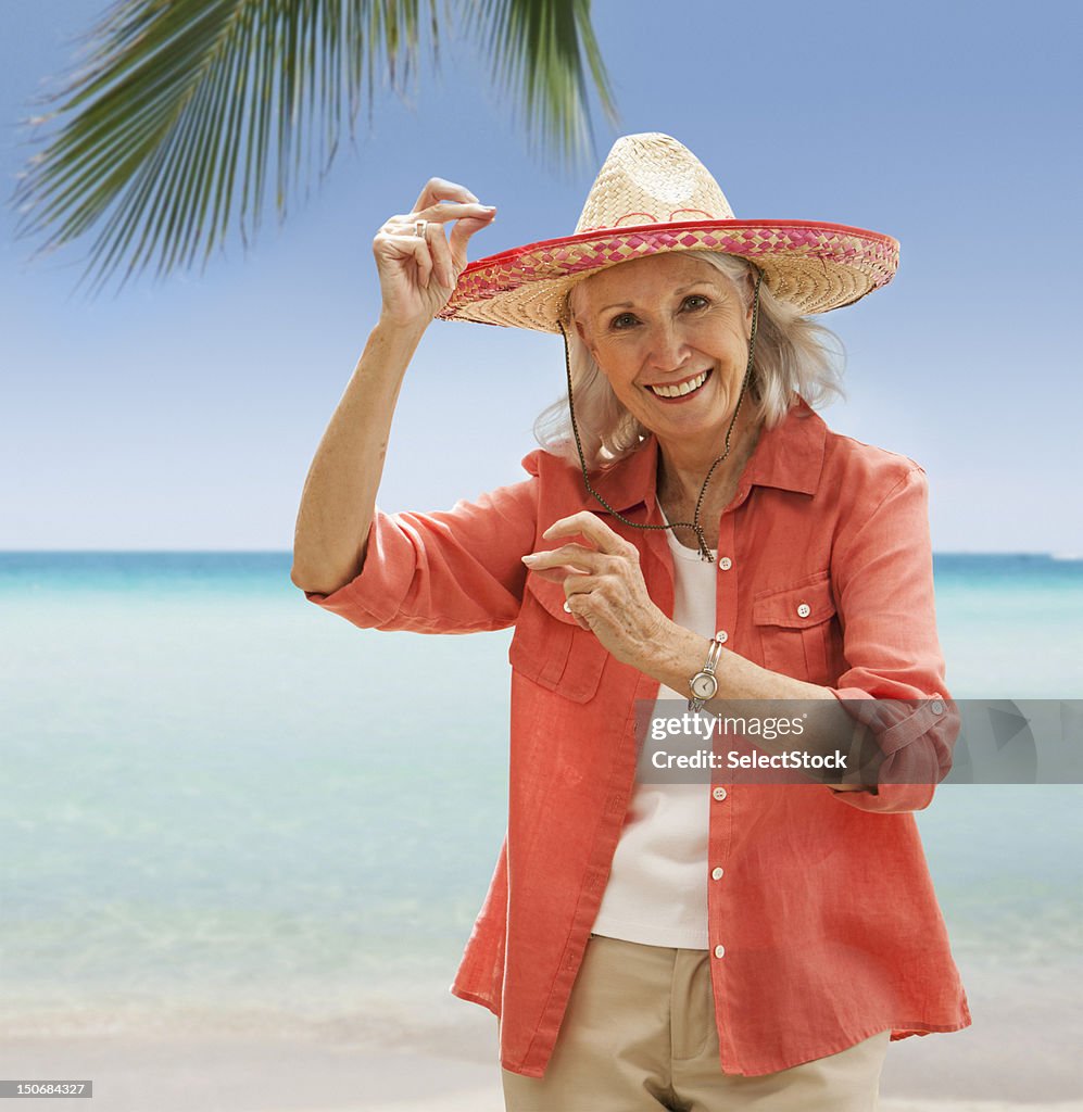 Senior woman on beach  snapping fingers