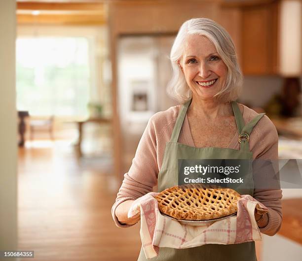 senior woman holding up pie - pie bildbanksfoton och bilder
