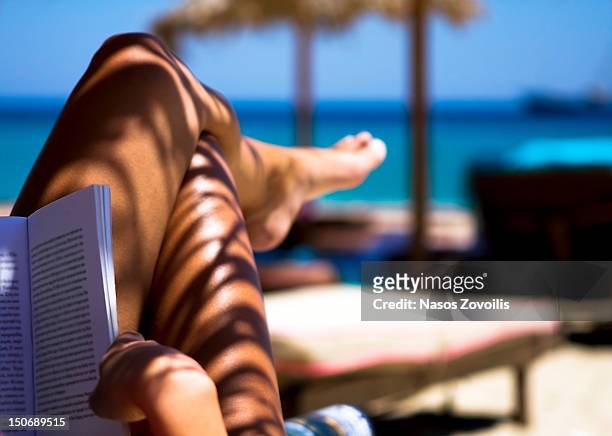 woman reading book - beach book reading stock-fotos und bilder