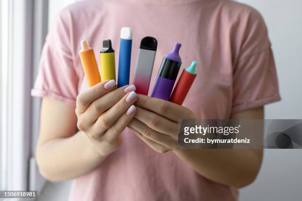 vape cigarettes in woman hand - electronic cigarette smoke stockfoto's en -beelden