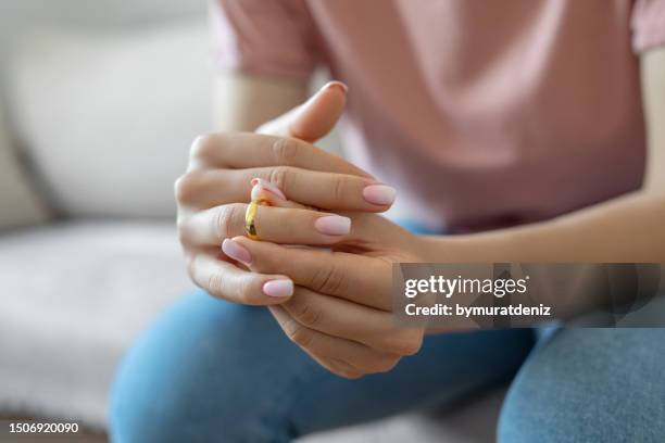 woman taking off wedding ring - divorce stock pictures, royalty-free photos & images