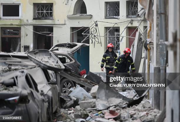 Rescuers work in a apartment building partially destroyed by a missile strike in the western Ukrainian city of Lviv on July 6 amid Russian military...
