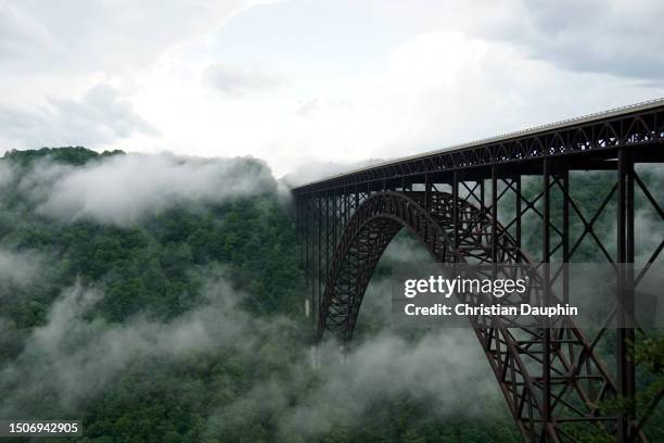 new river gorge bridge in fog. - région des appalaches photos et images de collection
