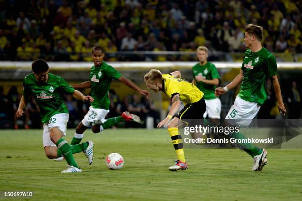 Sebastian Proedl of Bremen challenges Marco Reus of Dortmund during the Bundesliga match between Borussia Dortmund and Werder Bremen at Signal Iduna...