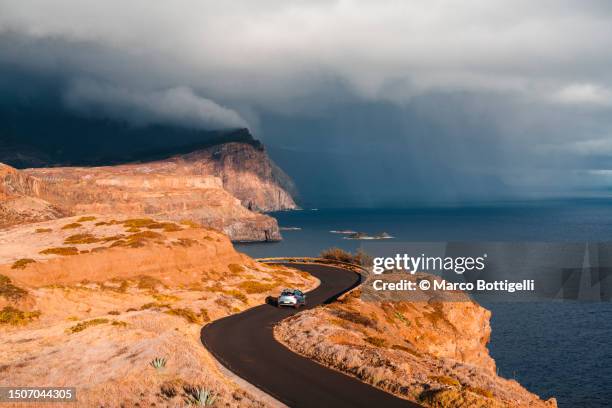 car driving on winding coastal road, madeira island, portugal - dramatic landscape stock pictures, royalty-free photos & images