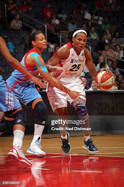 Monique Currie of the Washington Mystics drives against Armintie Price of the Atlanta Dream at the Verizon Center on August 24, 2012 in Washington,...