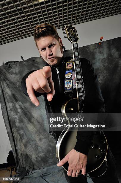 Portrait of Bill Kelliher, rhythm guitarist with American heavy metal group Mastodon, posing with his 82 Silverburst Gibson Les Paul guitar backstage...