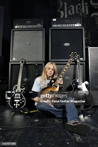 Portrait of musician Ben Wells, rhythm guitarist with American rock group Black Stone Cherry posing with his equipment, including a Gibson Les Paul...