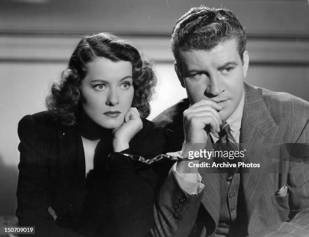 Ellen Drew and Robert Preston are handcuffed in a scene from the film 'Night Of January 16th', 1941.
