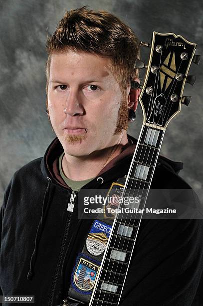 Portrait of Bill Kelliher, rhythm guitarist with American heavy metal group Mastodon, posing with his 82 Silverburst Gibson Les Paul guitar backstage...