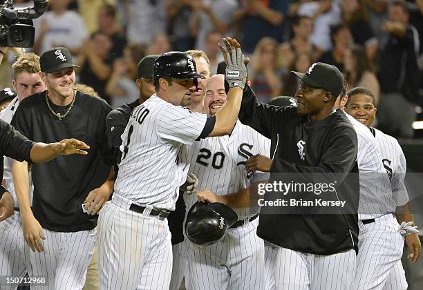 Orlando Hudson of the Chicago White Sox high-fives teammate Paul Konerko after Konerko hit a game-winning double scoring Dewayne Wise during the...