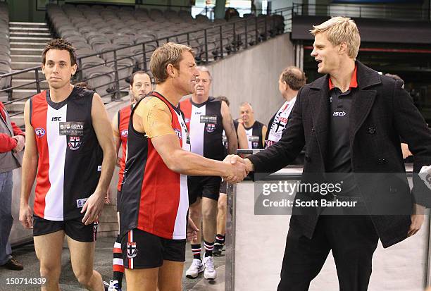 Shane Warne talks with Nick Riewoldt of the Saints before playing a game of Aussie Rules football as he takes part in the St Kilda Thank You Round...