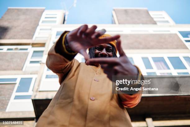 smiling african man posing with finger frame - fashion director stock-fotos und bilder