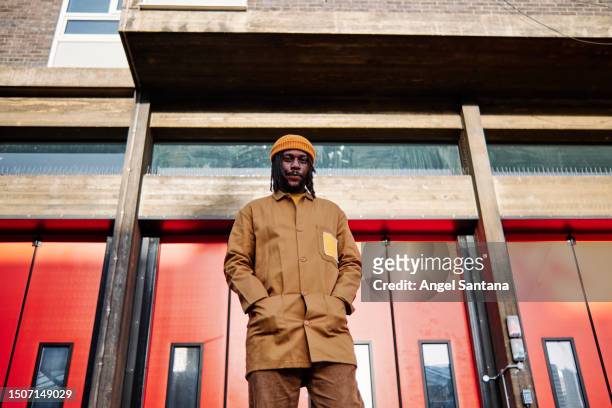 portrait of a young african man posing against the backdrop on the street - door way stock pictures, royalty-free photos & images