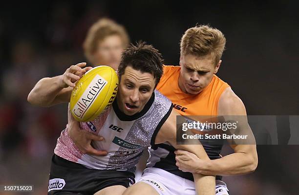 Stephen Milne of the Saints is tackled during the round 22 AFL match between the St Kilda Saints and the Greater Western Sydney Giants at Etihad...