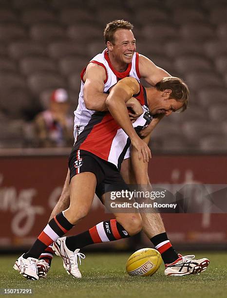 Shane Warne is tackled by Max Hudghton during the St Kilda Thank You Round charity match at Etihad Stadium on August 25, 2012 in Melbourne, Australia.