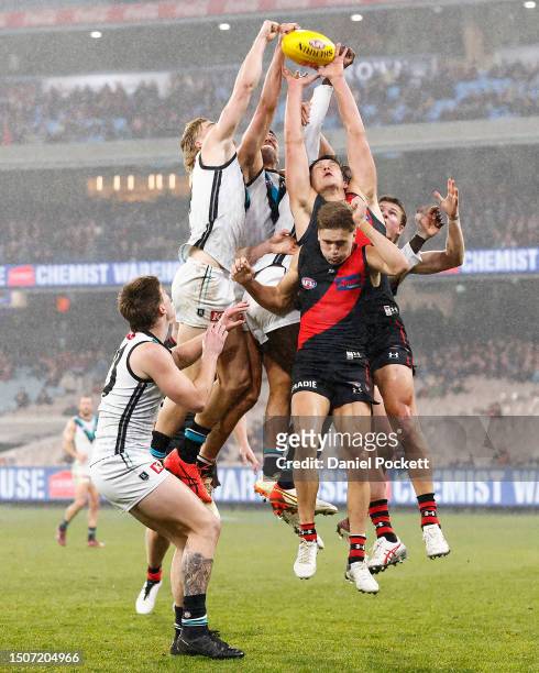 Miles Bergman of the Power and Ryan Burton of the Power spoil Sam Weideman of the Bombers during the round 16 AFL match between Essendon Bombers and...