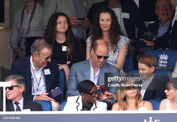 Prince William, Prince of Wales and Prince George of Wales hold a replica Ashes Urn while sitting next to Richard Thompson, Chairman of the...