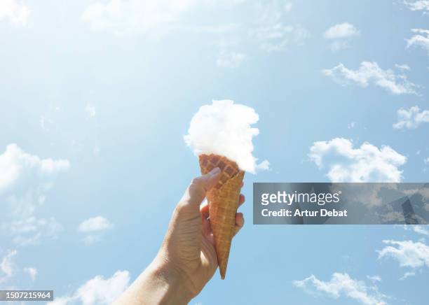 creative picture of an ice cream cone made of cloud. - personal perspective or pov stockfoto's en -beelden