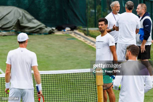 Novak Djokovic of Serbia talks to Andy Murray of Great Britain during a practice session ahead of The Championships Wimbledon 2023 at All England...