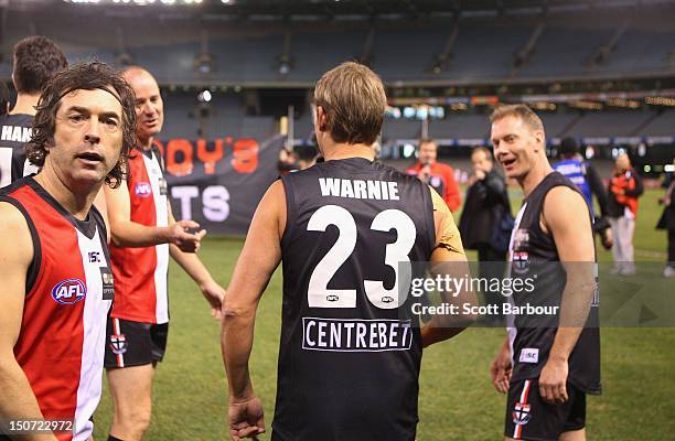 Shane Warne walks onto the field before playing a game of Aussie Rules football as he takes part in the St Kilda Thank You Round charity match at...