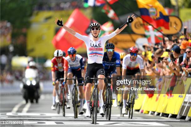 Tadej Pogacar of Slovenia and UAE Team Emirates crosses the finish line as third place and celebrates the victory of his teammate Adam Yates of...