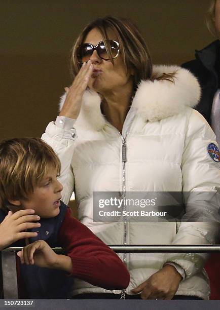 Elizabeth Hurley blows a kiss as she watches Shane Warne play a game of Aussie Rules football along with Damian Hurley as Shane Warne takes part in...