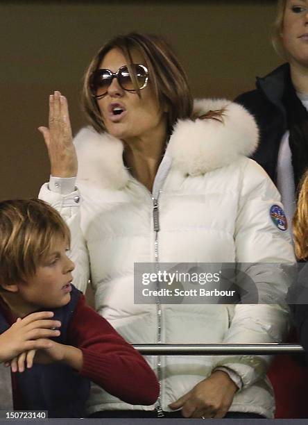 Elizabeth Hurley blows a kiss as she watches Shane Warne play a game of Aussie Rules football along with Damian Hurley as Shane Warne takes part in...