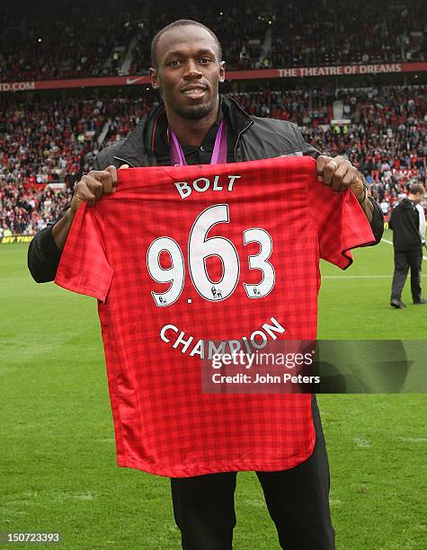 Olympic gold medallist Usain Bolt poses on the pitch ahead of the Barclays Premier League match between Manchester United and Fulham at Old Trafford...