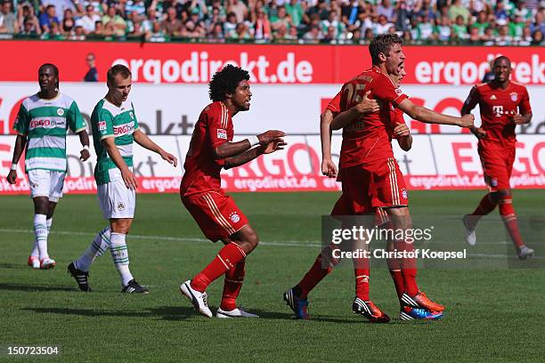 Thomas Mueller of Bayern celebrates the first goal with Holger Badstuber and Dante of bayern during the Bundesliga match between Greuther Fuerth and...