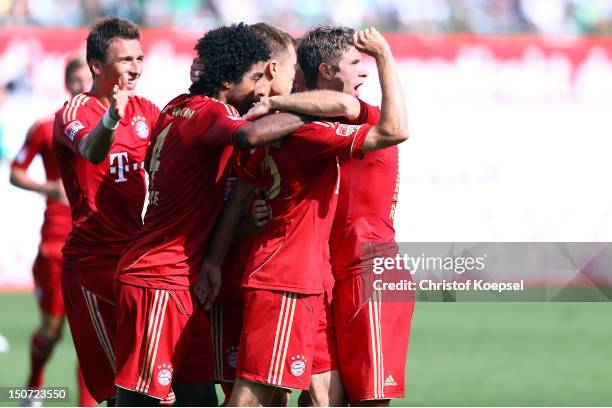 Thomas Mueller of Bayern celebrates the first goal with Mario Mandzukic and Dante of Bayern during the Bundesliga match between Greuther Fuerth and...